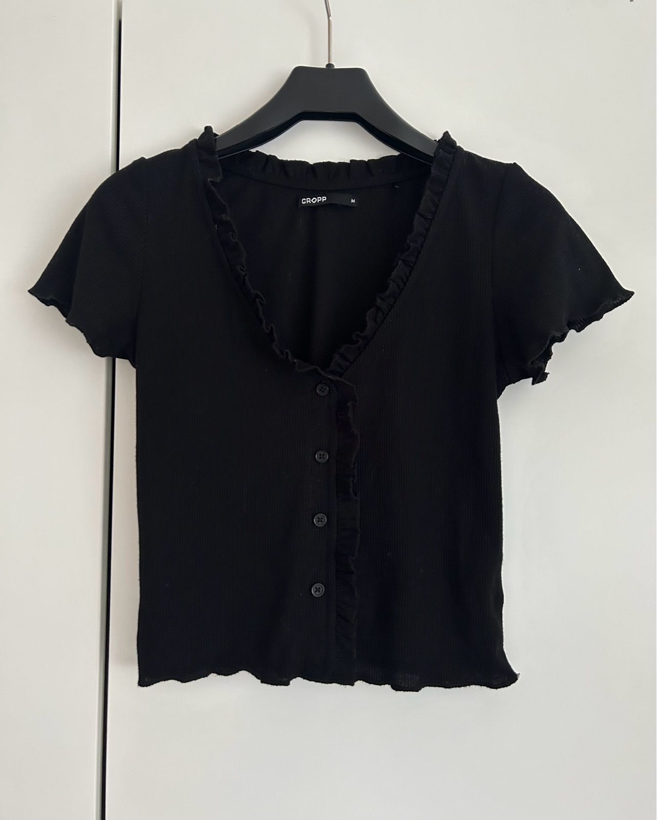 Black ruffle button top